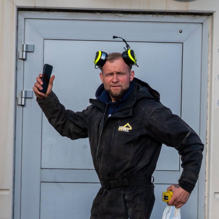 Terje Husby Rasmussen fra Husby Maskin AS på jobb i arbeidstøy med firmalogo